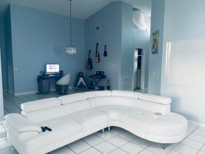 ein weißes Sofa in einem Zimmer mit blauer Wand in der Unterkunft WORLD CUP! LUXURY 3Bd ENTIRE HOME POMPANO BEACH- AIRPORT-BEACH-GOLF in Margate