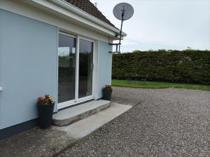 a white house with two potted plants on the porch at Ard Falcon in Cork