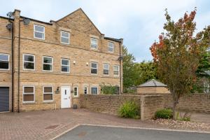 a large brick building with a white door at 4 Bedroom House in Addingham Ilkley in Addingham