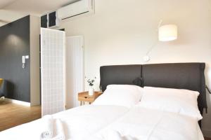 斯維諾烏伊希切的住宿－Wisus - Luxury Apartments，一间卧室配有一张带白色床单的大床
