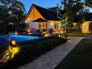 una casa con piscina por la noche en Garden Retreat Guest House, en Ciudad del Cabo