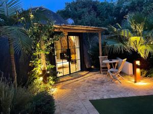 un patio con mesa y sillas por la noche en Garden Retreat Guest House, en Ciudad del Cabo