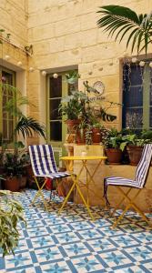 a patio with two chairs and a table and plants at Myrtle Suite - Valletta ground floor apartment in Valletta