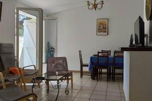 a living room with a blue table and chairs at Freisquéro in Bandol