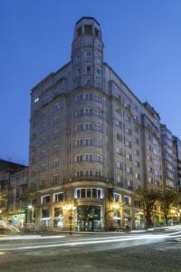 ein großes Gebäude in der Nacht auf einer Stadtstraße in der Unterkunft Zenit Vigo in Vigo