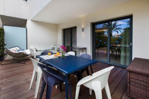 uma sala de jantar com uma mesa azul e cadeiras brancas em Luxury garden apartment 2BR in the best development of Cap d'Antibes-Juan les Pins em Antibes