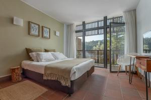 um quarto com uma cama e uma varanda em Alamal River Club em Gavião