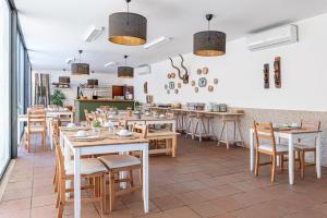 restauracja ze stołami i krzesłami w pokoju w obiekcie Alamal River Club w mieście Gavião