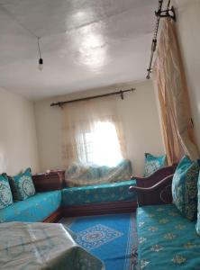 uma sala de estar com um sofá e uma janela em شقة للكراء اليومي في شفشاون em Chefchaouen