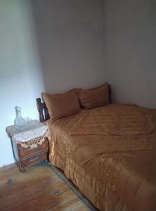 uma cama num quarto com uma mesa ao lado em شقة للكراء اليومي في شفشاون em Chefchaouen