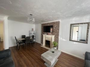 a living room with a table and a fireplace at Corby Guest House in Corby