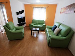 a living room with two green couches and a table at Villa Antonia in Medulin