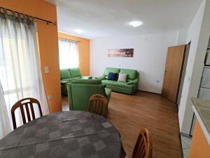 a living room with a green couch and a table at Villa Antonia in Medulin