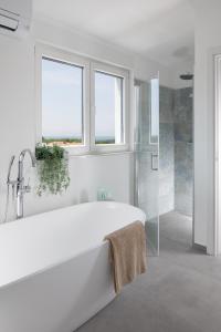 Ένα μπάνιο στο Penthouse Blue Horizon- a luxury penthouse with infinity pool, hot tub and sea views!