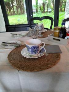 une table avec une tasse et une plaque sur une table dans l'établissement Chez Pascale & Christian, à Langoat