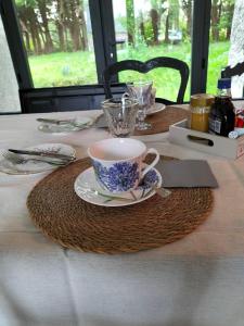 a table with a cup and a plate on a table at Chez Pascale & Christian in Langoat +29 photos