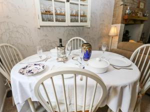 a white table with white chairs and a white table cloth at Ludd Brook Cottage in Halifax +21 photos