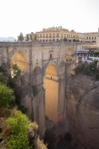 a bridge with a yellow door on a cliff at Hotel Palacio de Hemingway in Ronda