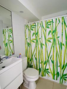 ein Bad mit einem WC und einem Wandbild aus Bambus in der Unterkunft Papudo. Familiar, 3D-2B. Tranquilo condominio cerca de la playa in Papudo
