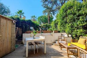 patio con tavolo, sedie e recinzione di Appartement Villeneuve Loubet Plage - Spacieux avec Jardin a Villeneuve-Loubet