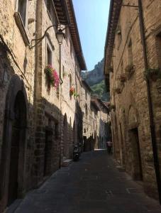 un vicolo stretto con edifici e una moto su una strada di La Dimora di Pietra a Gubbio