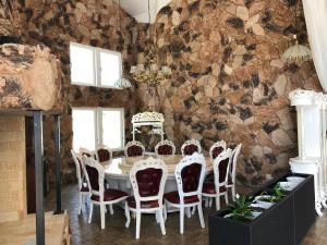 a table and chairs in a room with a stone wall at Skulesjön Hotell in Bjästa