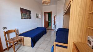 una pequeña habitación con una cama y una silla en Villa Jolies, en Viddalba