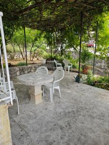 a table and chairs sitting under a pavilion at Apartman Ljubo in Podgora