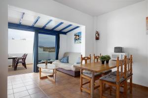 een woonkamer met een tafel en een bank bij Vista al Mar, La Graciosa in Caleta de Sebo