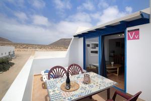 einen Tisch und Stühle auf einem Balkon mit Blick auf die Wüste in der Unterkunft Vista al Mar, La Graciosa in Caleta de Sebo