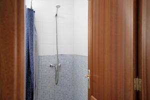 uma casa de banho com um chuveiro e azulejos azuis em Vista al Mar, La Graciosa em Caleta de Sebo