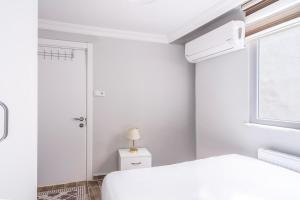 a white bedroom with a bed and a window at Flat w Balcony 10 min to Uskudar Coast in Istanbul