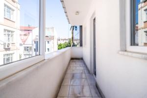 an empty corridor in a white building with windows at Flat w Balcony 10 min to Uskudar Coast in Istanbul