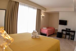 um quarto de hotel com uma cama com um animal de toalha em Verdello Home em Savoca