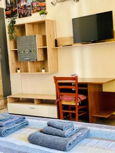シラクーサにあるCasa Sikaniaのデスク、椅子、テレビが備わる客室です。