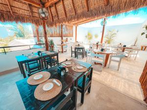 une salle à manger avec des tables et des chaises dans un restaurant dans l'établissement Hotel Boutique Naj Casa Holbox, à Holbox