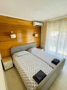 1 dormitorio con 1 cama con pared de madera en La Pineda 2 en Calafell