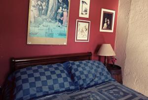 カストロにあるChacara Baillyのベッドルーム1室(ベッド1台付)が備わります。壁には絵画が飾られています。
