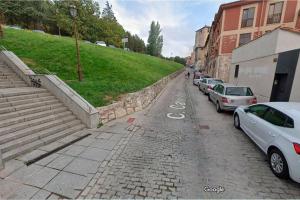 a street with cars parked on the side of a hill at Precioso Estudio junto a la catedral in Burgos