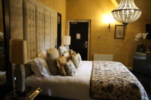Un dormitorio con una cama grande con almohadas. en Cairn Lodge en Auchterarder
