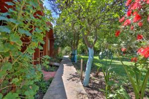 a garden with blue painted trees and flowers at Cinderella Pension & Bungalow in Cıralı