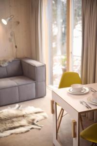 een woonkamer met een tafel en een bank bij Eastside Woodshed - Pentland cabin set in the hills near Edinburgh in Penicuik