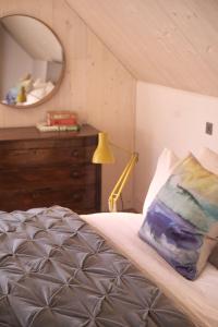a bedroom with a bed with a dresser and a mirror at Eastside Woodshed - Pentland cabin set in the hills near Edinburgh in Penicuik
