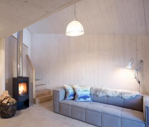 a living room with a couch and a fireplace at Eastside Woodshed - Pentland cabin set in the hills near Edinburgh in Penicuik