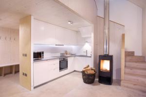 a kitchen with a fireplace in the middle of a room at Eastside Woodshed - Pentland cabin set in the hills near Edinburgh in Penicuik