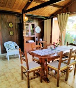 een eetkamer met een houten tafel en stoelen bij Villamare in Custonaci