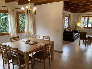 Un comedor con mesa y sillas de madera. en Casa Roble - AndarLibre, en San Martín de los Andes