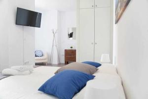 1 cama blanca con almohadas azules en una habitación en Comodo Y Agradable Apartamento En Madrid Centro 6, en Madrid