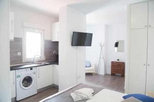 Biała kuchnia z pralką i zlewem w obiekcie Comodo y agradable estudio en Madrid centro A6 w Madrycie