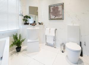奧奇特阿德的住宿－Cairn Lodge，白色的浴室设有卫生间和水槽。